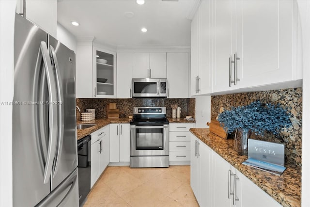 8538 NE 4th Ave, El Portal, FL 33138 - kitchen with appliances with stainless steel finishes, dark stone counters, white cabinetry, glass insert cabinets, and recessed lighting