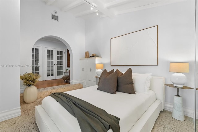 8538 NE 4th Ave, El Portal, FL 33138 - bedroom featuring arched walkways, rail lighting, baseboards, beamed ceiling, and french doors