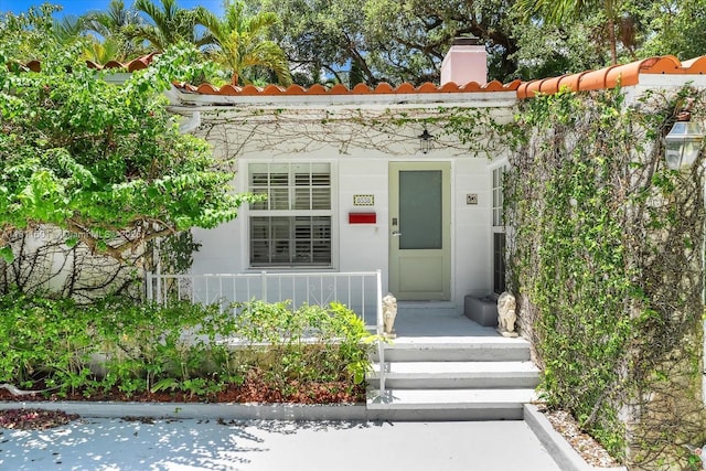 8538 NE 4th Ave, El Portal, FL 33138 - property entrance featuring a chimney and a tile roof