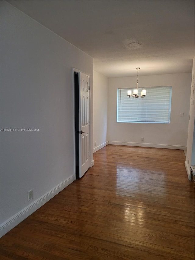 340 84th St Unit 2, Miami Beach, FL 33141 - unfurnished room featuring a chandelier, wood finished floors, and baseboards