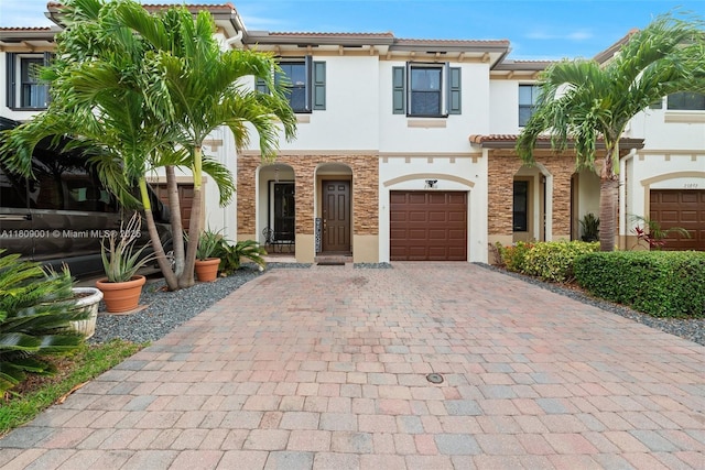 23900 SW 118th Ave, Homestead, FL 33032 - view of front of home featuring decorative driveway, stucco siding, stone siding, a garage, and a tiled roof