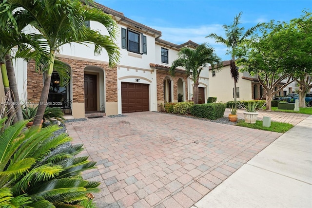 23900 SW 118th Ave, Homestead, FL 33032 - mediterranean / spanish house featuring decorative driveway, stucco siding, an attached garage, and stone siding