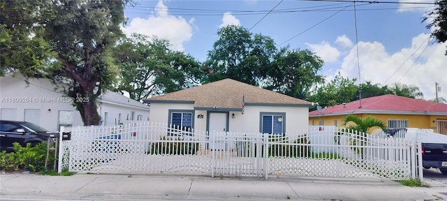 4223 NW 32nd Ave, Miami, FL 33142 - bungalow featuring stucco siding, a fenced front yard, and roof with shingles
