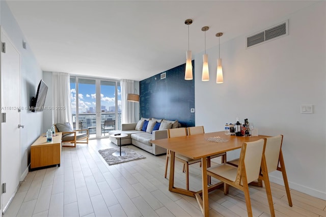 2602 E Hallandale Beach Blvd Unit R1709, Hallandale Beach, FL 33009 - dining room featuring expansive windows, baseboards, and light wood finished floors