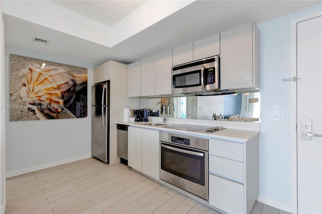 2602 E Hallandale Beach Blvd Unit R1709, Hallandale Beach, FL 33009 - kitchen with appliances with stainless steel finishes, a sink, light countertops, baseboards, and white cabinetry
