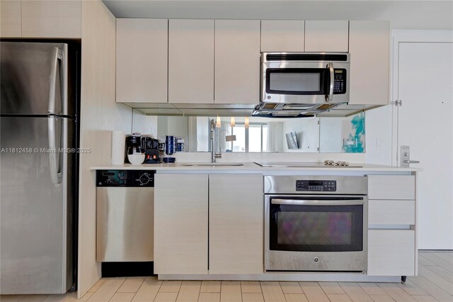 2602 E Hallandale Beach Blvd Unit R1709, Hallandale Beach, FL 33009 - kitchen featuring stainless steel appliances, light countertops, white cabinets, and a sink