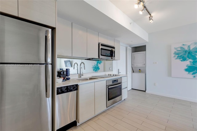 2602 E Hallandale Beach Blvd Unit R1709, Hallandale Beach, FL 33009 - kitchen with stainless steel appliances, stacked washer / dryer, a sink, light countertops, and baseboards