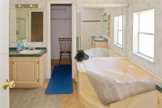 3906 Court St, Zephyrhills, FL 33541 - bathroom featuring wallpapered walls, vanity, and a garden tub