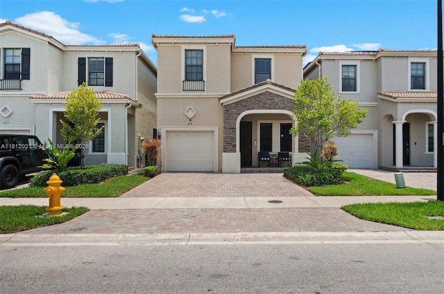 659 NE 191st St, Miami, FL 33179 - mediterranean / spanish house featuring a garage, stucco siding, decorative driveway, a tile roof, and stone siding