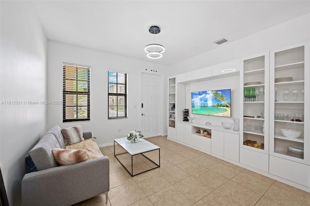 659 NE 191st St, Miami, FL 33179 - living room with built in shelves, light tile patterned flooring, and baseboards