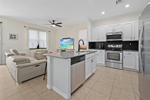 659 NE 191st St, Miami, FL 33179 - kitchen with appliances with stainless steel finishes, a sink, open floor plan, tasteful backsplash, and light tile patterned floors