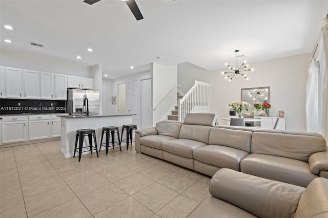 659 NE 191st St, Miami, FL 33179 - living room with a chandelier, light tile patterned floors, recessed lighting, a ceiling fan, and stairs