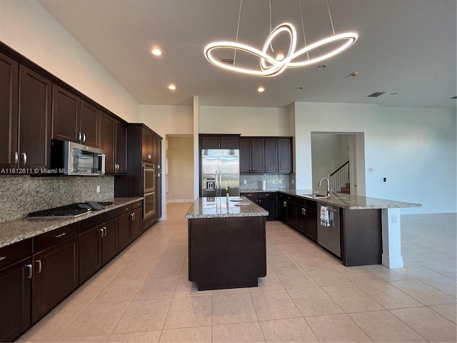 8248 Lost Creek Ln, Delray Beach, FL 33446 - kitchen featuring stainless steel appliances, a sink, a peninsula, decorative backsplash, and light stone countertops