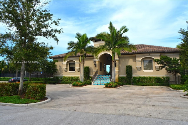 8248 Lost Creek Ln, Delray Beach, FL 33446 - mediterranean / spanish-style house featuring stucco siding, uncovered parking, and a tiled roof