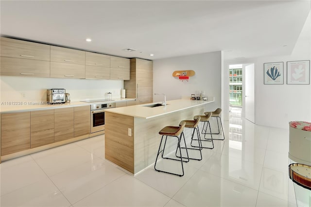 1300 S Miami Ave Unit 1610, Miami, FL 33130 - kitchen with oven, modern cabinets, a breakfast bar area, a sink, and recessed lighting