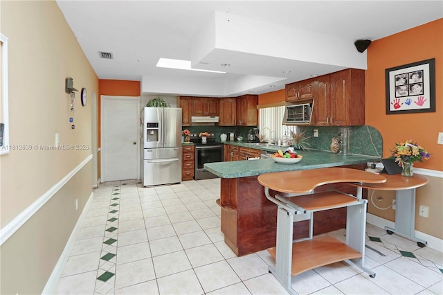 17501 SW 89th Ave, Palmetto Bay, FL 33157 - kitchen with stainless steel appliances, under cabinet range hood, a peninsula, tasteful backsplash, and light tile patterned floors