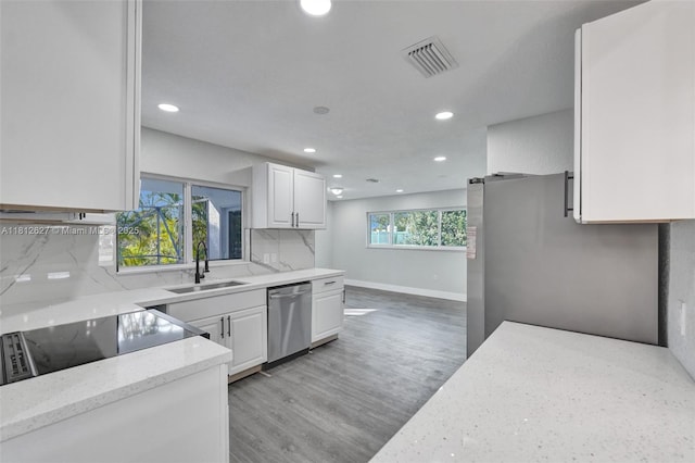 8400 NW 7th St, Pembroke Pines, FL 33024 - kitchen with appliances with stainless steel finishes, a sink, light stone countertops, white cabinets, and backsplash
