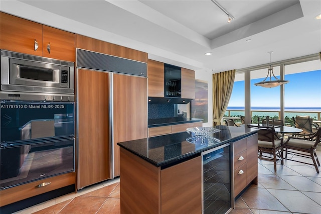 19955 NE 38th Ct Unit 2204, Aventura, FL 33180 - kitchen featuring built in appliances, beverage cooler, light tile patterned floors, dark stone counters, and a center island