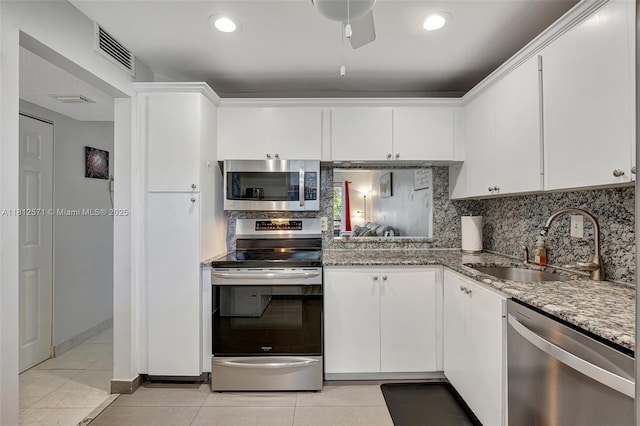 3170 Holiday Springs Blvd Unit 6-209, Margate, FL 33063 - kitchen with appliances with stainless steel finishes, light tile patterned floors, a sink, white cabinetry, and backsplash