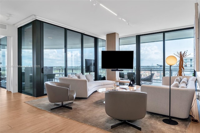 8701 Collins Ave Unit 905, Miami Beach, FL 33154 - living room featuring expansive windows, wood finished floors, healthy amount of natural light, and rail lighting