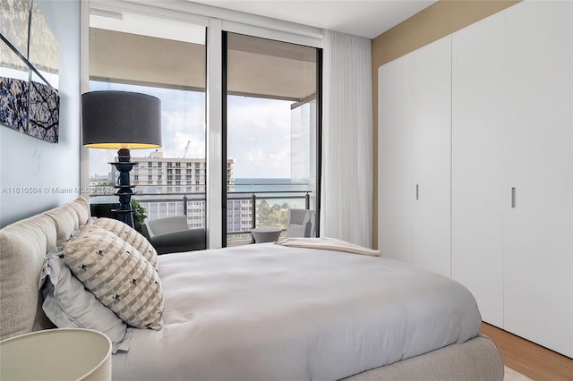 8701 Collins Ave Unit 905, Miami Beach, FL 33154 - bedroom with wood finished floors, floor to ceiling windows, and a closet