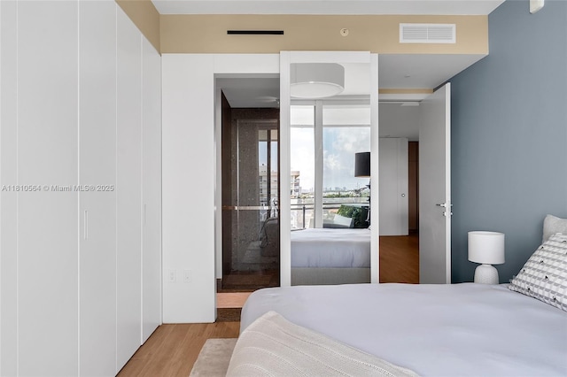 8701 Collins Ave Unit 905, Miami Beach, FL 33154 - bedroom featuring wood finished floors and a wall of windows