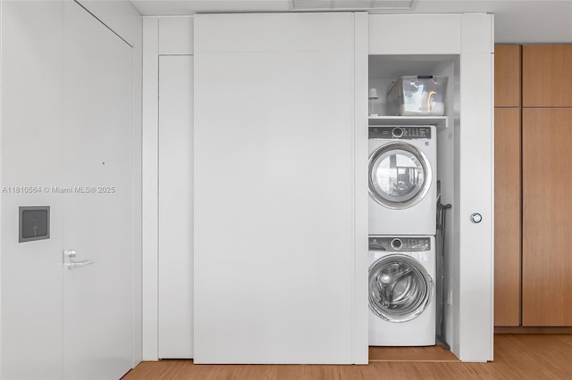 8701 Collins Ave Unit 905, Miami Beach, FL 33154 - laundry area featuring stacked washing machine and dryer and wood finished floors