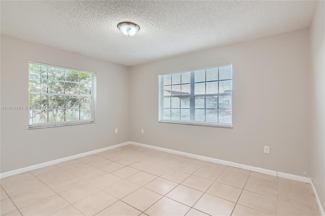 20316 NW 32nd Path, Miami Gardens, FL 33056 - spare room featuring plenty of natural light, a textured ceiling, light tile patterned floors, and baseboards