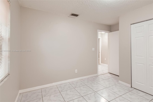 20316 NW 32nd Path, Miami Gardens, FL 33056 - unfurnished bedroom featuring a closet, a textured ceiling, baseboards, and multiple windows