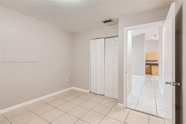 20316 NW 32nd Path, Miami Gardens, FL 33056 - unfurnished bedroom featuring a closet, a textured ceiling, light tile patterned floors, and baseboards