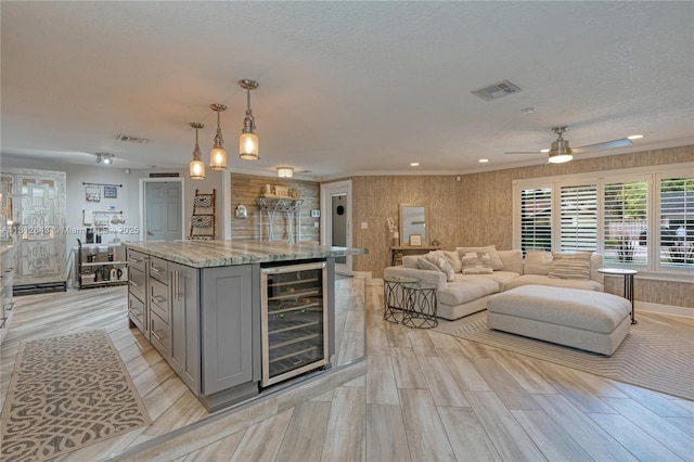 2750 SW 86th Way, Davie, FL 33328 - kitchen with gray cabinetry, wine cooler, ceiling fan, light stone countertops, and a kitchen island