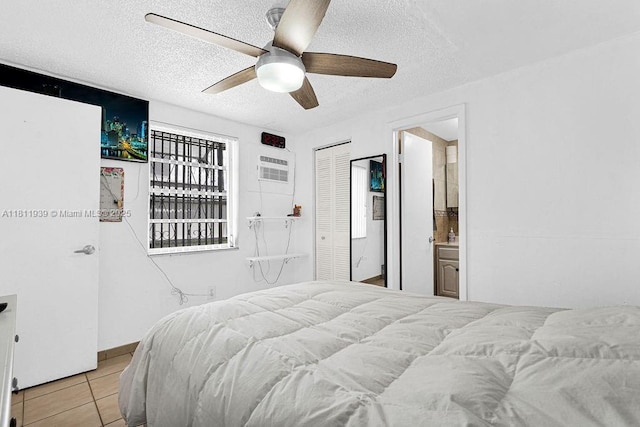 911 E 9th Pl, Hialeah, FL 33010 - bedroom featuring a textured ceiling, a closet, light tile patterned floors, a wall mounted air conditioner, and a ceiling fan