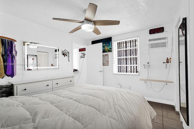 911 E 9th Pl, Hialeah, FL 33010 - tiled bedroom with a wall unit AC, a textured ceiling, and a ceiling fan