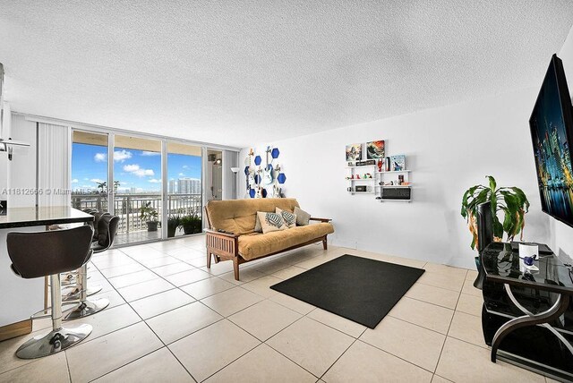 18041 Biscayne Blvd Unit 1201, Aventura, FL 33160 - living room featuring floor to ceiling windows, a textured ceiling, and light tile patterned flooring