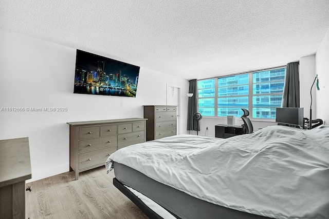 18041 Biscayne Blvd Unit 1201, Aventura, FL 33160 - bedroom with a textured ceiling, wood finished floors, and baseboards