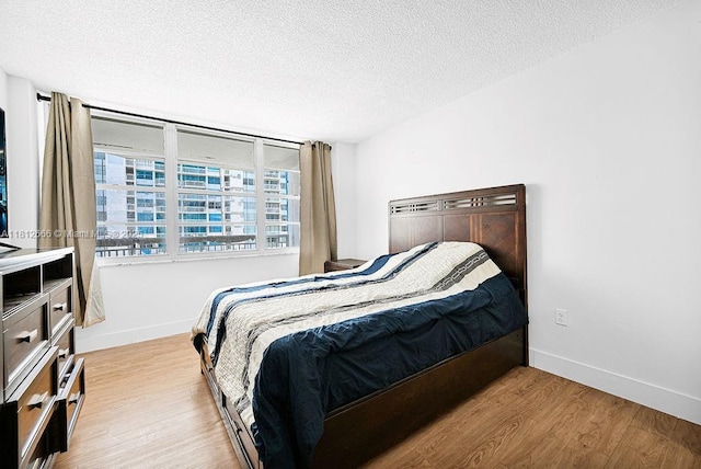 18041 Biscayne Blvd Unit 1201, Aventura, FL 33160 - bedroom featuring wood finished floors, a textured ceiling, and baseboards