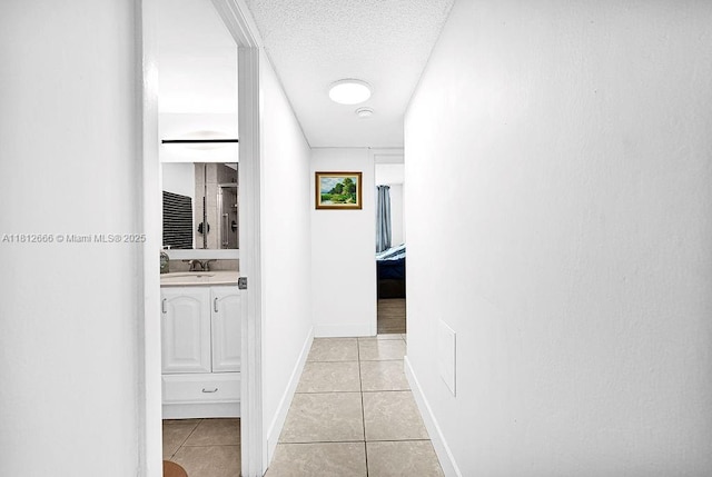 18041 Biscayne Blvd Unit 1201, Aventura, FL 33160 - corridor featuring light tile patterned floors, a sink, a textured ceiling, and baseboards