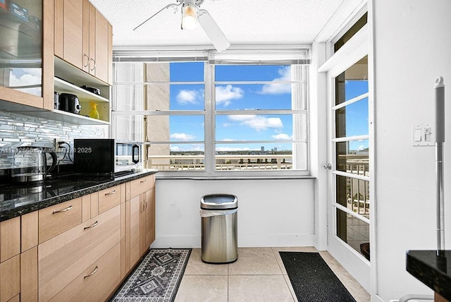18041 Biscayne Blvd Unit 1201, Aventura, FL 33160 - kitchen with black microwave, plenty of natural light, light brown cabinets, light tile patterned flooring, and a textured ceiling