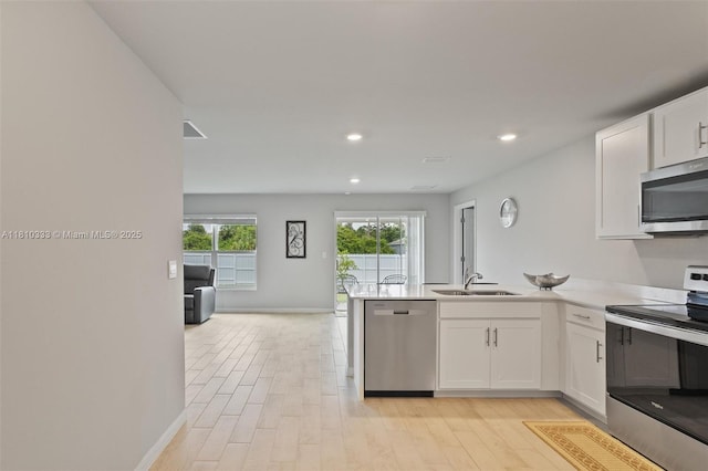 3021 June Cir Fl, LaBelle, FL 33935 - kitchen featuring stainless steel appliances, a sink, white cabinets, a peninsula, and recessed lighting