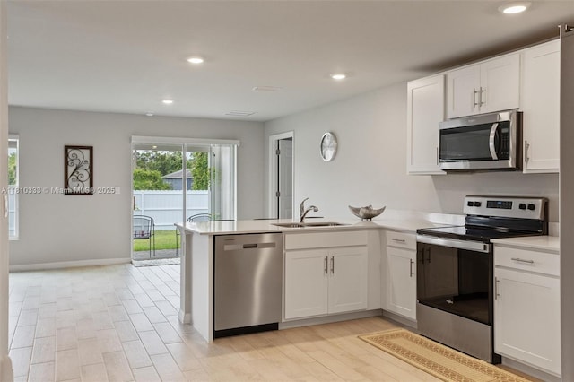 3021 June Cir Fl, LaBelle, FL 33935 - kitchen featuring stainless steel appliances, a sink, a peninsula, white cabinets, and recessed lighting