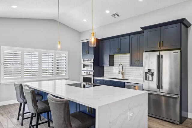 20141 NW 8th St, Pembroke Pines, FL 33029 - kitchen featuring stainless steel appliances, a sink, a kitchen island, vaulted ceiling, and decorative backsplash