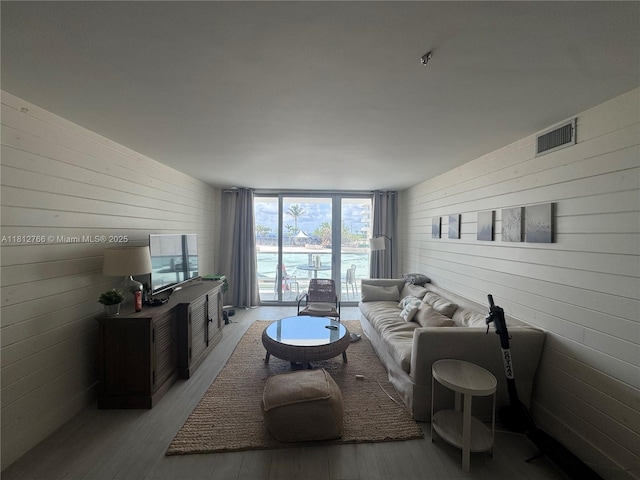 5161 Collins Ave Unit 315, Miami Beach, FL 33140 - living area featuring wood walls, wood finished floors, and a wall of windows