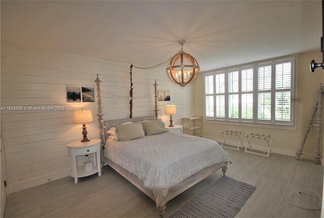 5161 Collins Ave Unit 315, Miami Beach, FL 33140 - bedroom featuring a chandelier, wood finished floors, and wooden walls