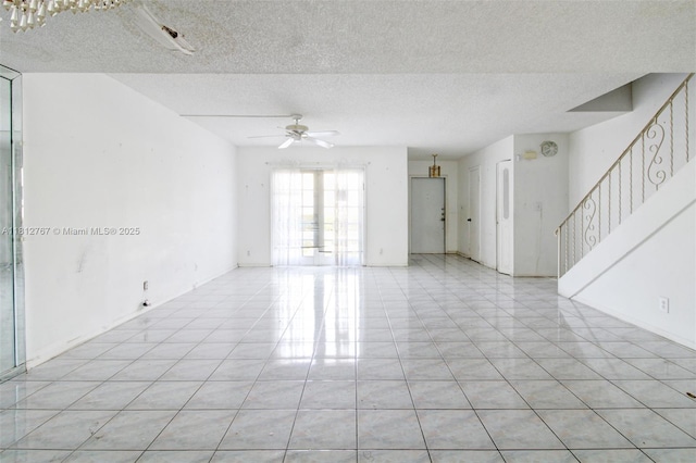 1006 NE 24th Ave Unit 190, Hallandale Beach, FL 33009 - empty room featuring ceiling fan, a textured ceiling, light tile patterned floors, and stairs