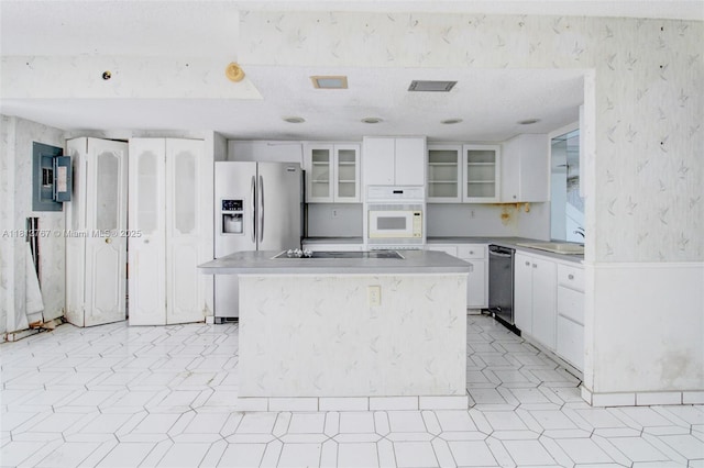 1006 NE 24th Ave Unit 190, Hallandale Beach, FL 33009 - kitchen with wallpapered walls, appliances with stainless steel finishes, electric panel, white cabinetry, and glass insert cabinets