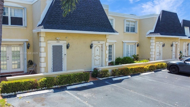 1006 NE 24th Ave Unit 190, Hallandale Beach, FL 33009 - view of front of house with roof with shingles, stucco siding, uncovered parking, and mansard roof