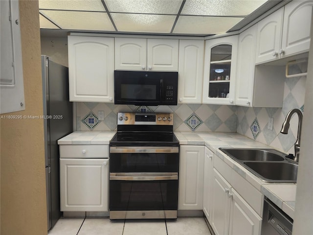 1061 NW 80th Ave Unit J, Margate, FL 33063 - kitchen with black microwave, double oven range, tile counters, dishwashing machine, and backsplash
