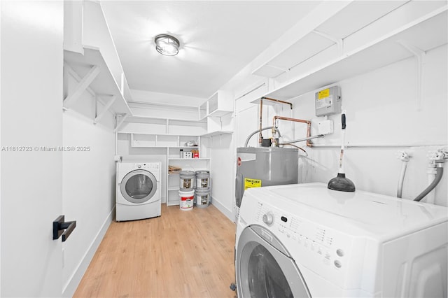 18801 NW 29th Ct, Miami Gardens, FL 33056 - washroom featuring washing machine and clothes dryer, baseboards, light wood-style floors, and electric water heater