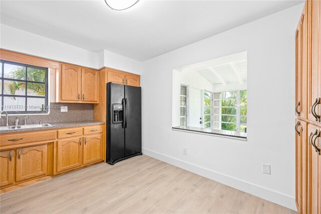 18801 NW 29th Ct, Miami Gardens, FL 33056 - kitchen featuring black refrigerator with ice dispenser, a sink, healthy amount of natural light, light wood-style flooring, and beam ceiling