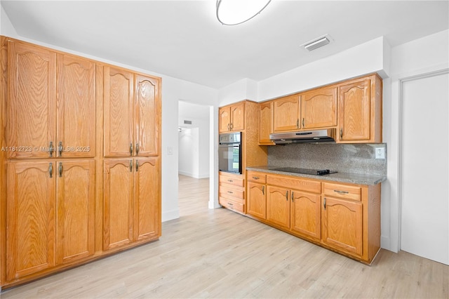 18801 NW 29th Ct, Miami Gardens, FL 33056 - kitchen featuring black appliances, under cabinet range hood, backsplash, light wood-style flooring, and brown cabinets